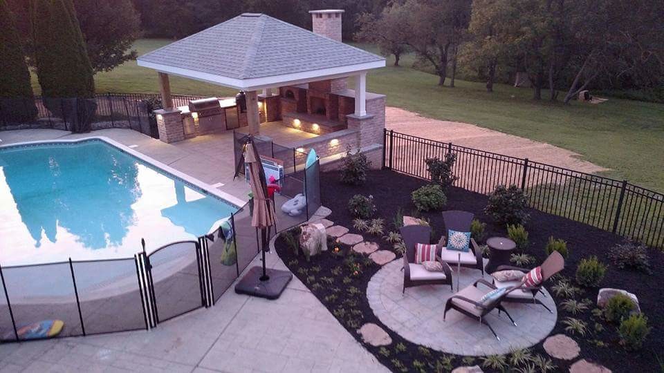 Diseño de casa de la piscina y piscina alargada clásica de tamaño medio rectangular en patio trasero con suelo de hormigón estampado