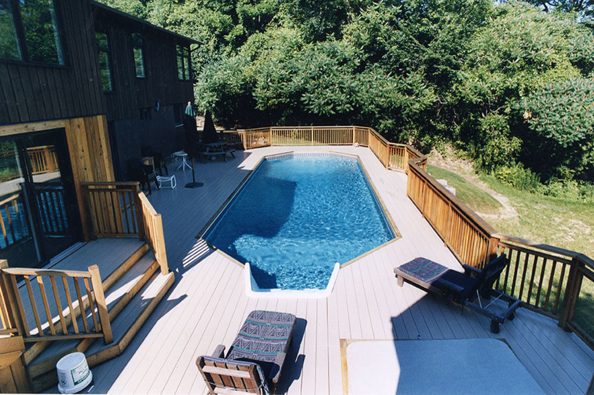 Foto på en stor medelhavsstil pool på baksidan av huset, med trädäck