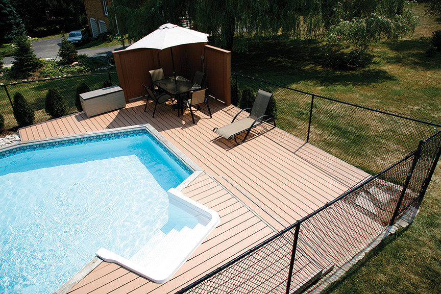 Ejemplo de piscina moderna grande a medida en patio trasero con entablado