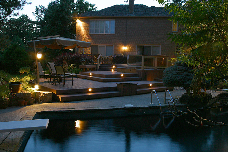 Large tuscan backyard custom-shaped pool photo in Toronto with decking