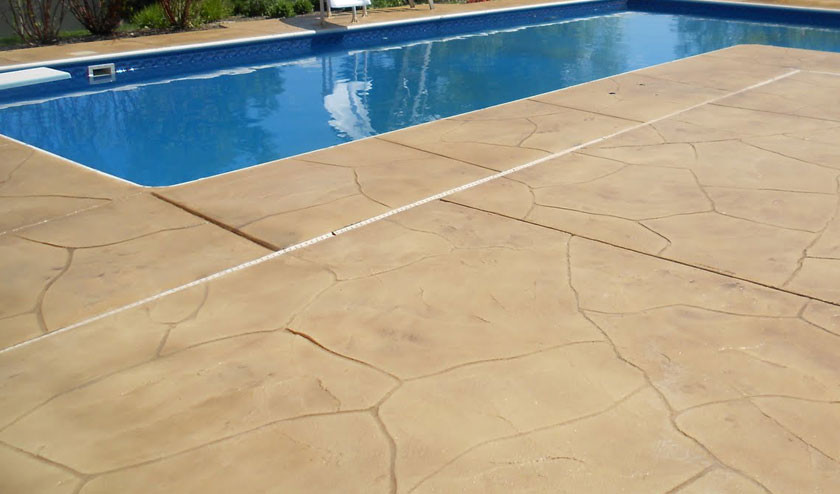 Inspiration för en amerikansk pool på baksidan av huset, med marksten i betong