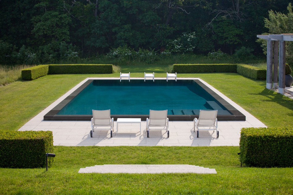 Diseño de piscina clásica renovada grande rectangular en patio trasero