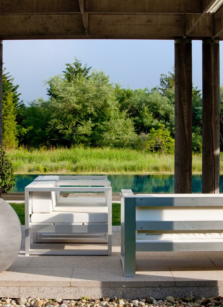 Cette photo montre une piscine arrière et à débordement moderne de taille moyenne et rectangle avec des pavés en pierre naturelle.
