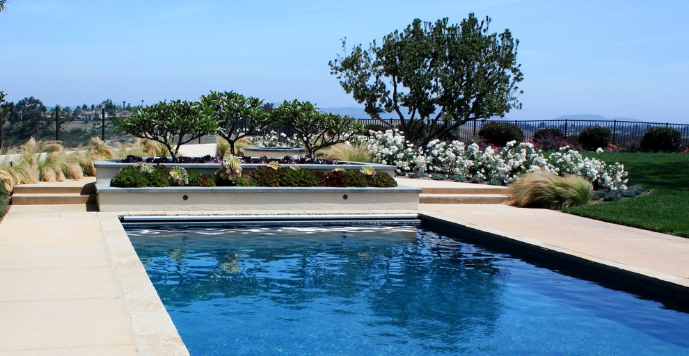 Großer Klassischer Schwimmteich hinter dem Haus in rechteckiger Form mit Wasserspiel und Betonboden in San Diego