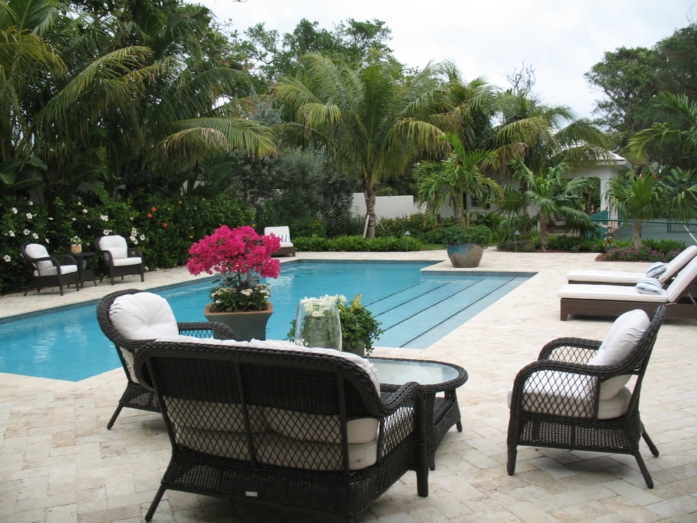Foto de piscina alargada exótica grande rectangular en patio trasero con adoquines de ladrillo