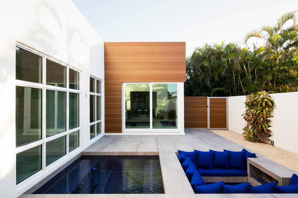 Ispirazione per una piscina design rettangolare dietro casa con pavimentazioni in cemento