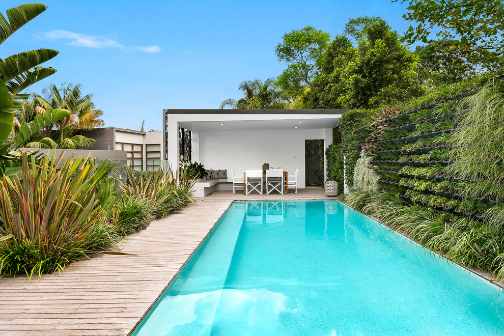 Medium sized contemporary back rectangular lengths swimming pool in Sydney with a pool house and decking.