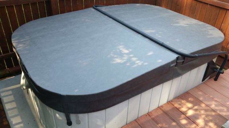 Mid-sized elegant backyard custom-shaped hot tub photo in Wilmington with decking