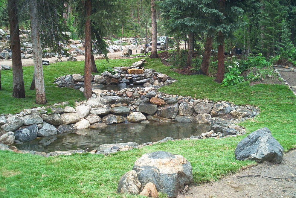 Foto di un'ampia piscina fuori terra stile rurale personalizzata davanti casa con fontane e pavimentazioni in pietra naturale