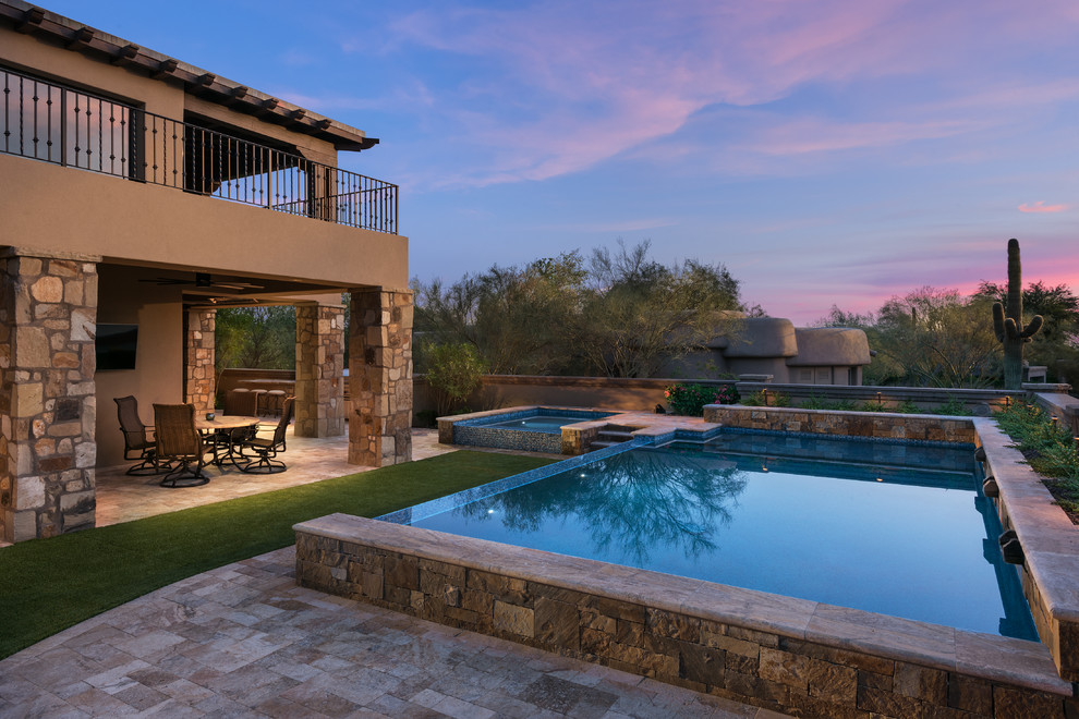 Großer Uriger Pool hinter dem Haus in rechteckiger Form mit Natursteinplatten in Phoenix