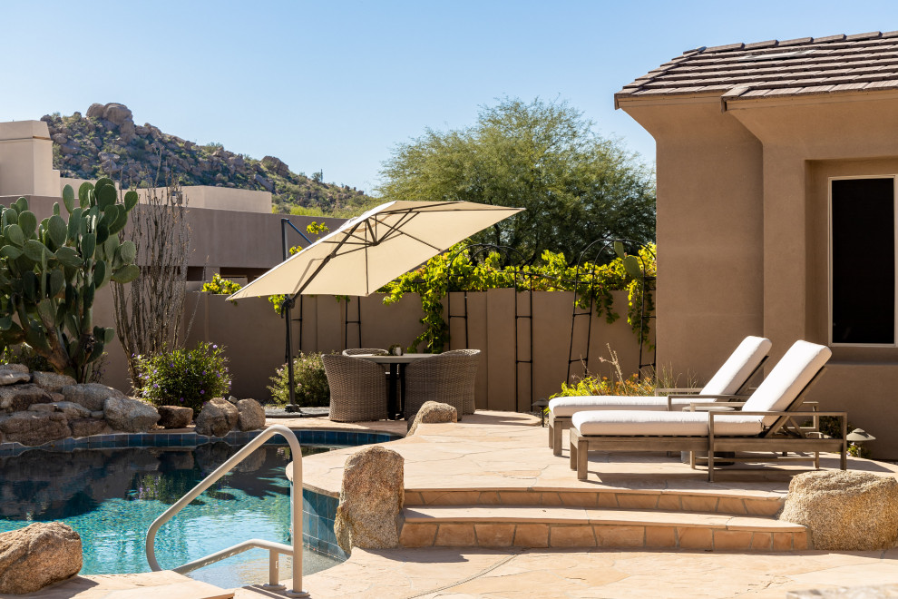Foto di una piscina stile americano personalizzata con pavimentazioni in pietra naturale