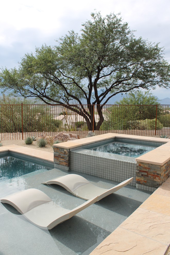 Ejemplo de piscinas y jacuzzis minimalistas de tamaño medio a medida en patio trasero con adoquines de piedra natural