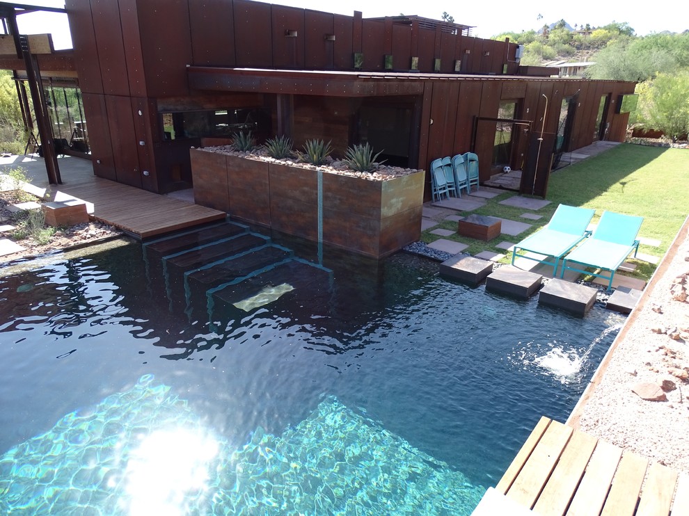 На фото: большой естественный, прямоугольный бассейн на заднем дворе в стиле лофт с