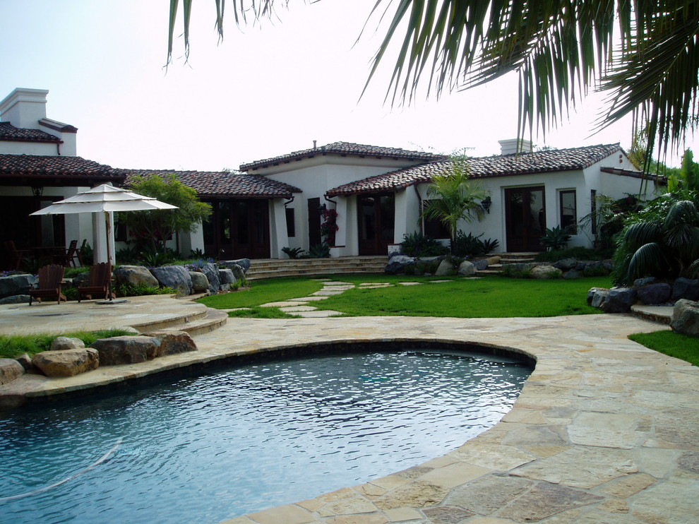 Modelo de piscinas y jacuzzis naturales mediterráneos grandes tipo riñón en patio trasero con adoquines de piedra natural
