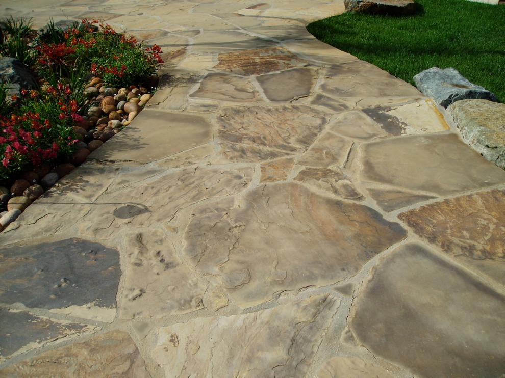 Photo of a large mediterranean back kidney-shaped natural hot tub in San Diego with natural stone paving.