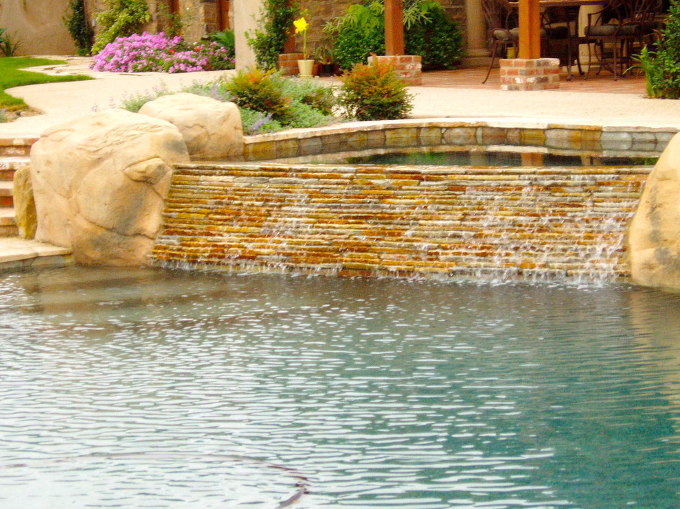 Inspiration for a mediterranean backyard concrete paver and custom-shaped hot tub remodel in San Diego