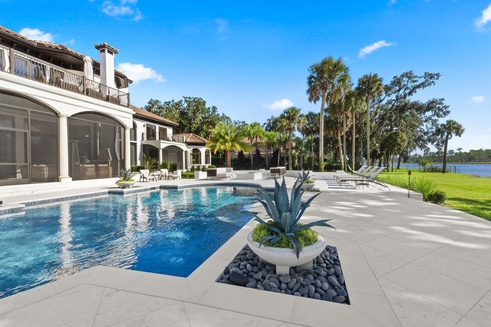 Example of a tuscan backyard stamped concrete and rectangular lap pool design in Jacksonville