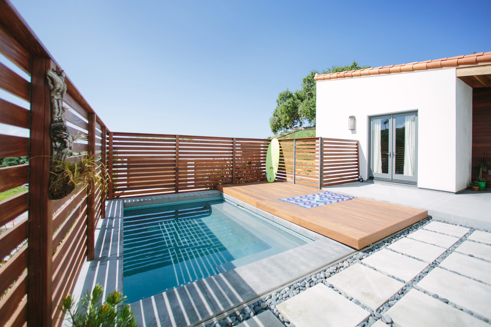 Ispirazione per una piscina contemporanea rettangolare dietro casa con pavimentazioni in cemento
