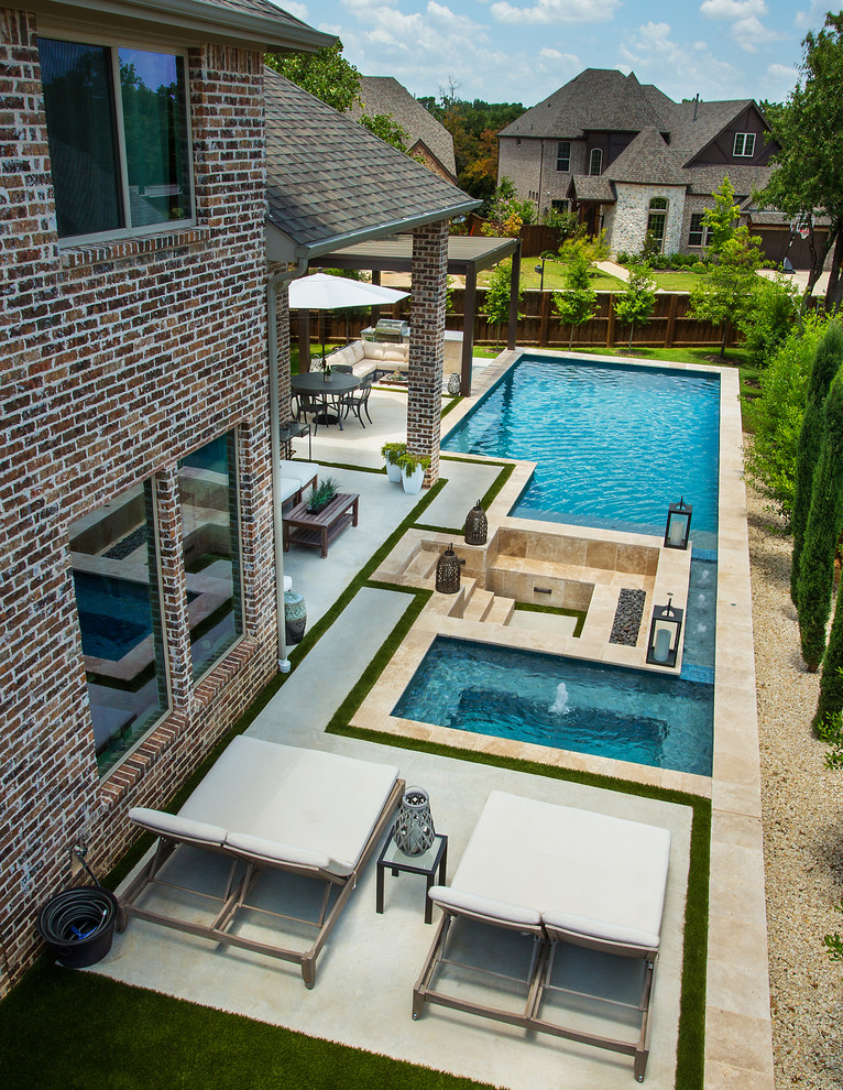 Ejemplo de piscinas y jacuzzis alargados tradicionales de tamaño medio rectangulares en patio trasero con losas de hormigón