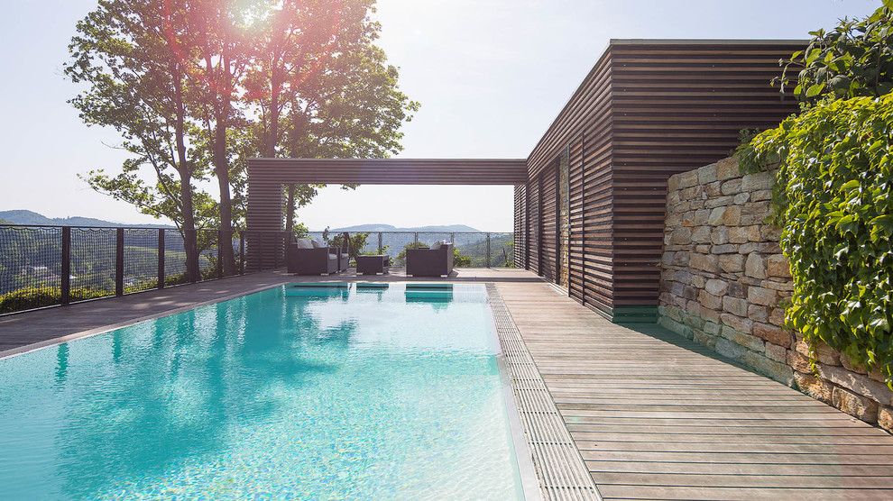 Esempio di una grande piscina moderna rettangolare dietro casa con pedane