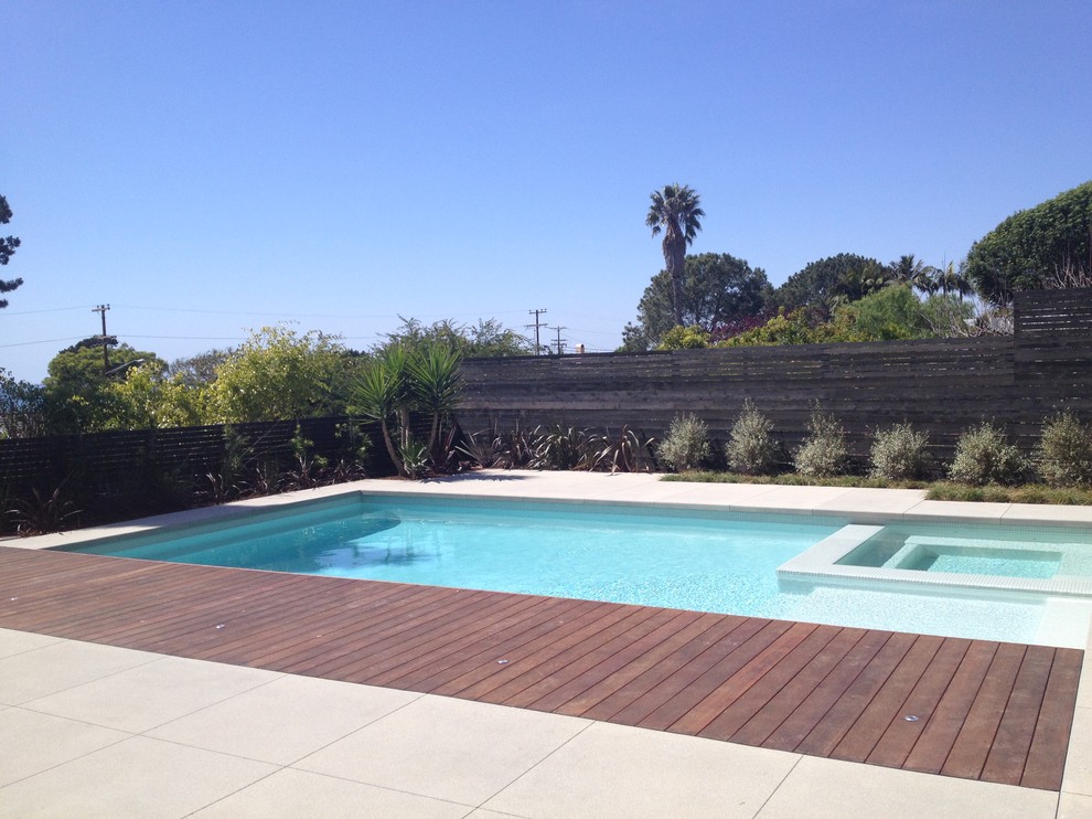 Foto de piscinas y jacuzzis modernos grandes rectangulares en patio trasero con losas de hormigón