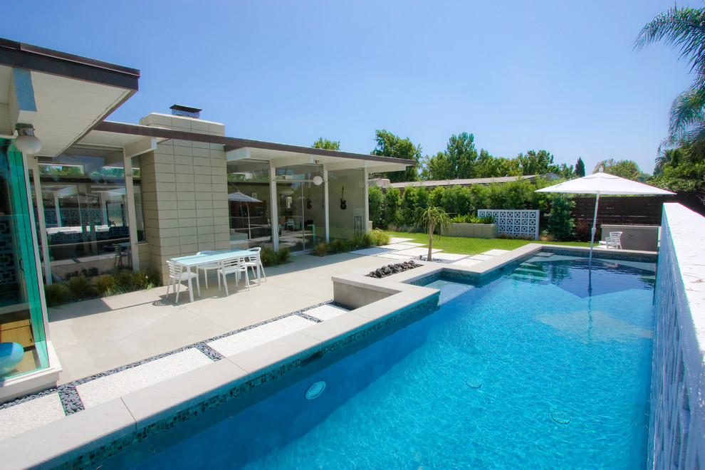 Ispirazione per una piscina fuori terra moderna rettangolare di medie dimensioni e dietro casa con lastre di cemento