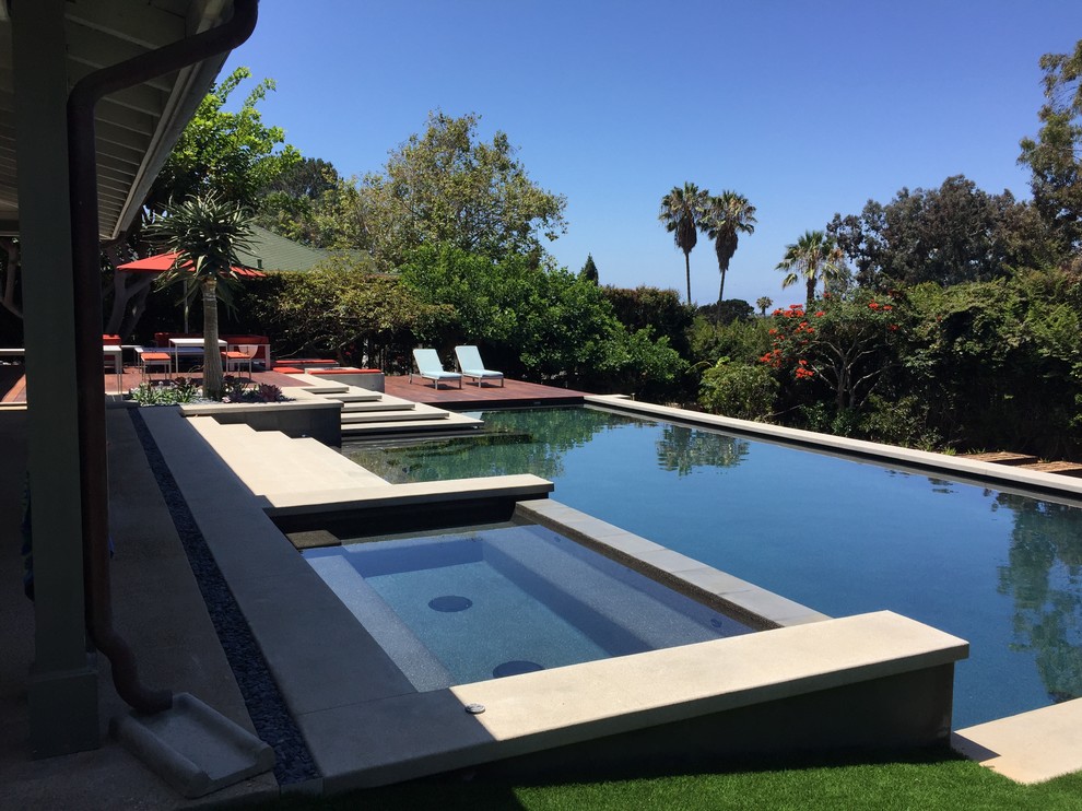 Ejemplo de piscina contemporánea grande rectangular en patio trasero con losas de hormigón