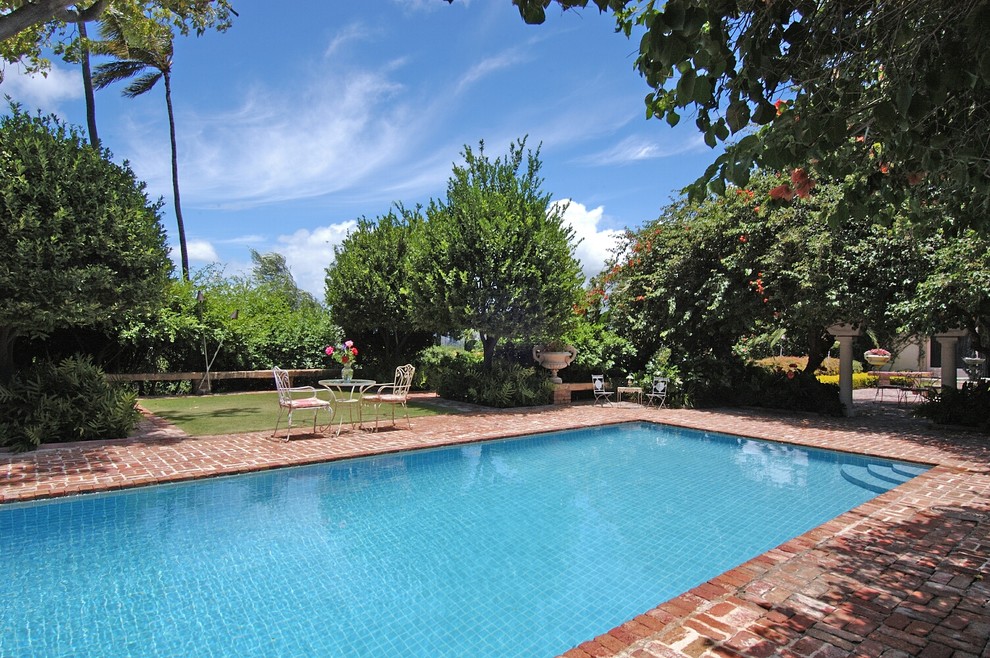 Medium sized world-inspired back rectangular lengths swimming pool in Hawaii with brick paving.