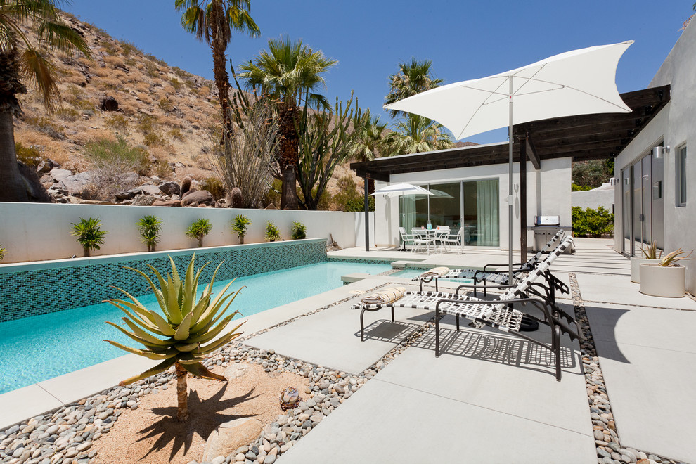 Идея дизайна: бассейн среднего размера, произвольной формы на заднем дворе в современном стиле с джакузи и мощением тротуарной плиткой