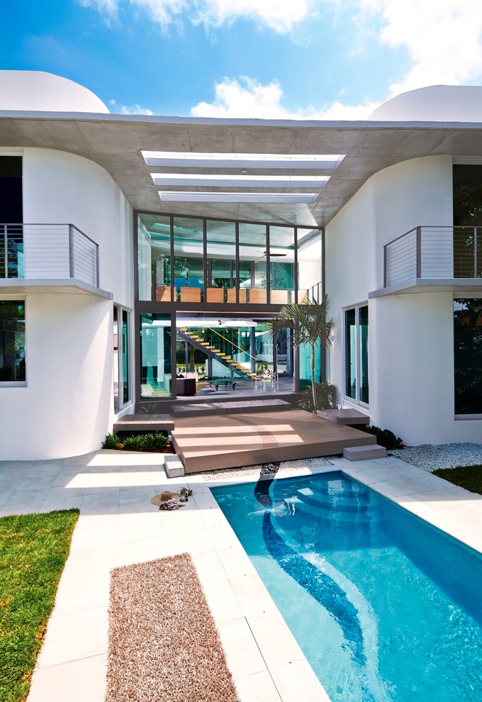Идея дизайна: спортивный, прямоугольный бассейн среднего размера на заднем дворе в стиле модернизм с фонтаном и покрытием из декоративного бетона