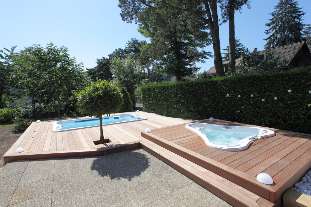 Idee per una grande piscina fuori terra contemporanea personalizzata dietro casa con una vasca idromassaggio e pedane