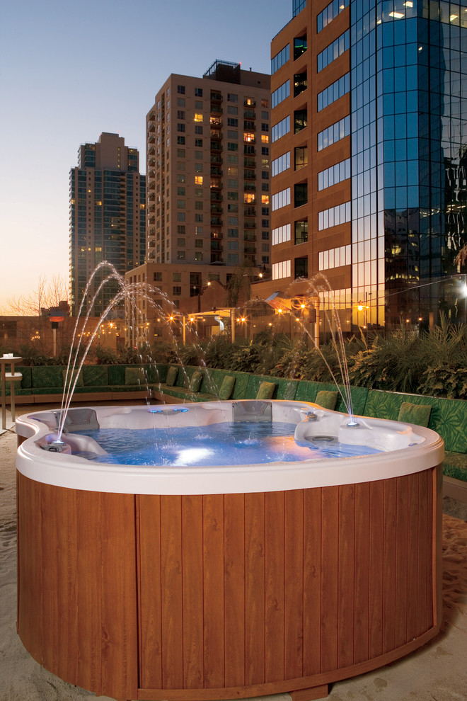 Foto di una grande piscina fuori terra design personalizzata dietro casa con una vasca idromassaggio e graniglia di granito