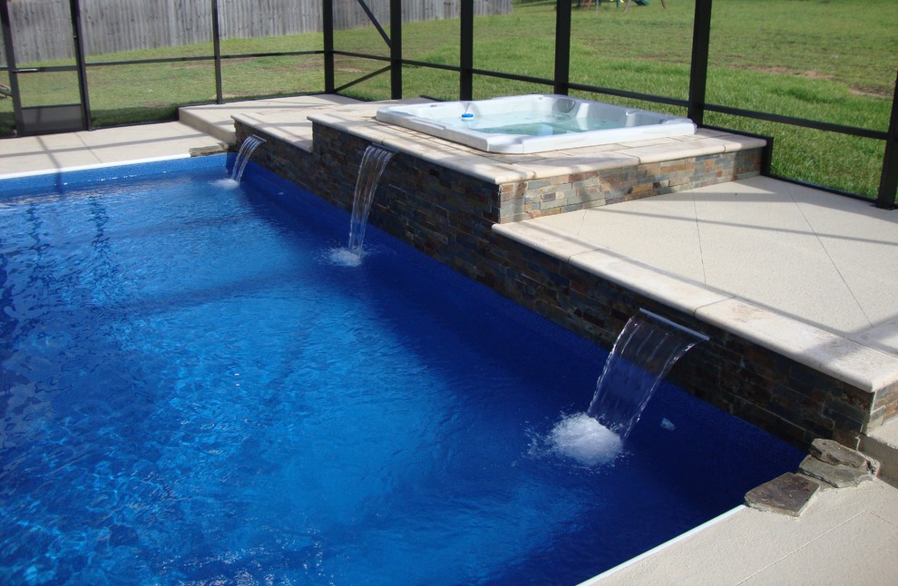 Ejemplo de piscinas y jacuzzis elevados contemporáneos de tamaño medio rectangulares en patio trasero con adoquines de hormigón