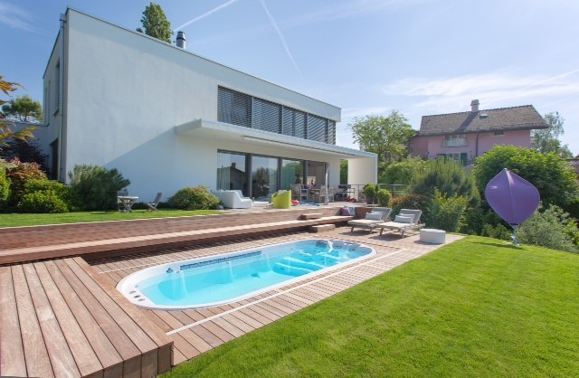 Esempio di una piscina fuori terra design rotonda di medie dimensioni e dietro casa con una vasca idromassaggio e pedane