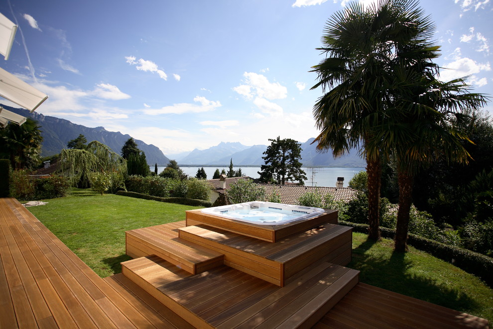 Idée de décoration pour une piscine hors-sol et arrière design de taille moyenne et rectangle avec un bain bouillonnant et une terrasse en bois.