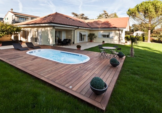 Réalisation d'une piscine hors-sol et arrière design de taille moyenne et ronde avec un bain bouillonnant et une terrasse en bois.