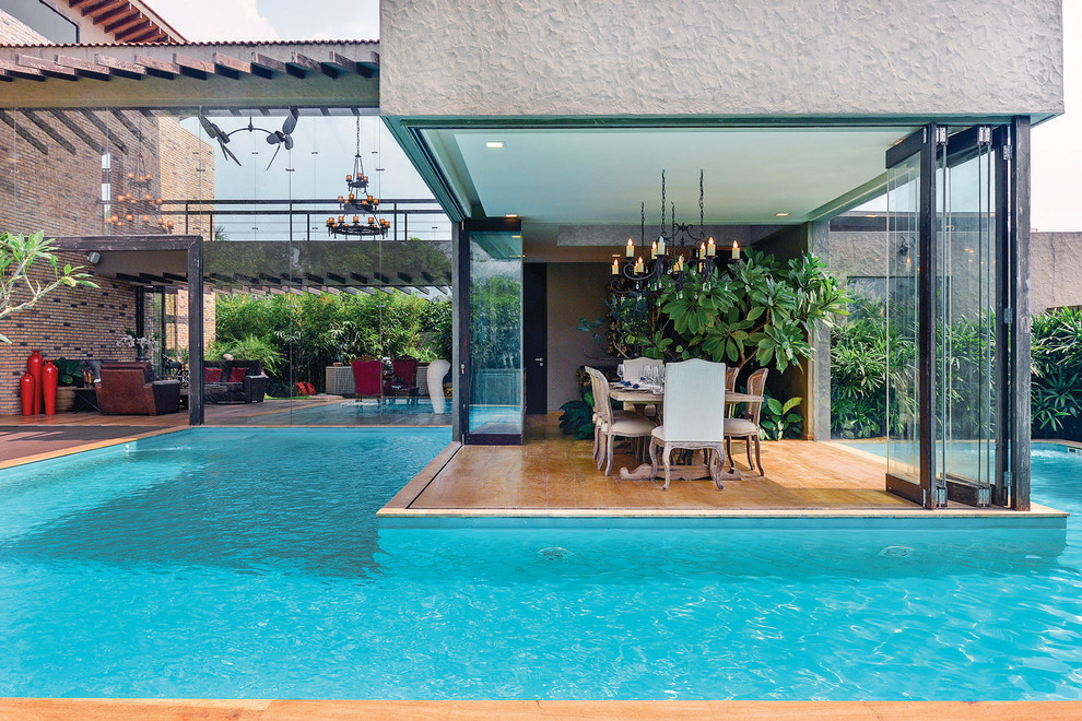 Пример оригинального дизайна: бассейн произвольной формы на заднем дворе в современном стиле с домиком у бассейна
