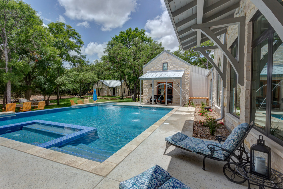 Idée de décoration pour une grande piscine à débordement et arrière champêtre rectangle avec un point d'eau et une dalle de béton.