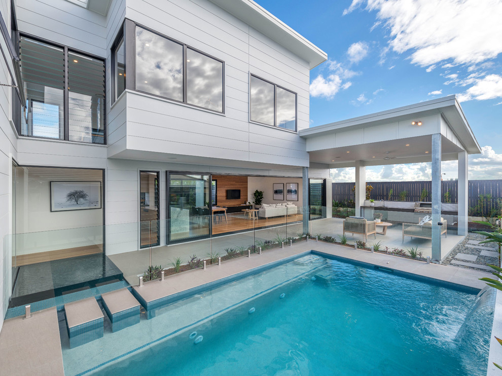 Foto di una piscina monocorsia minimal rettangolare di medie dimensioni e dietro casa con pavimentazioni in cemento