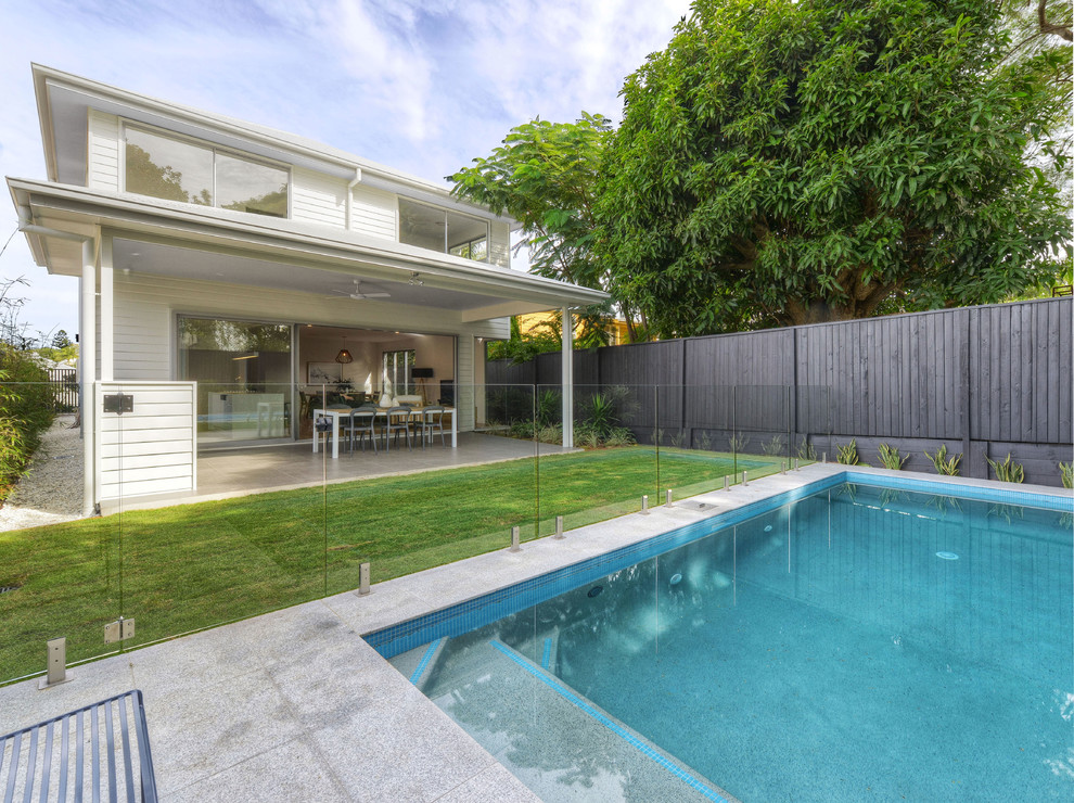 This is an example of a traditional back rectangular lengths swimming pool in Brisbane with concrete paving.