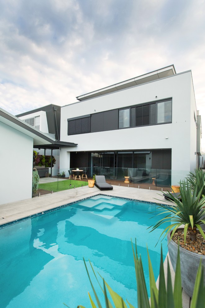 Photo of a large contemporary back rectangular lengths swimming pool in Newcastle - Maitland with concrete paving.