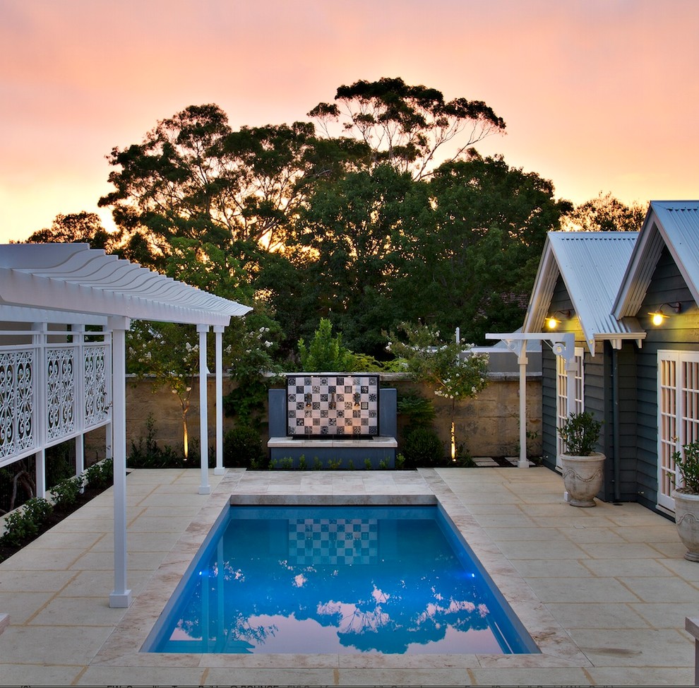 Ispirazione per una piscina design rettangolare dietro casa con pavimentazioni in pietra naturale