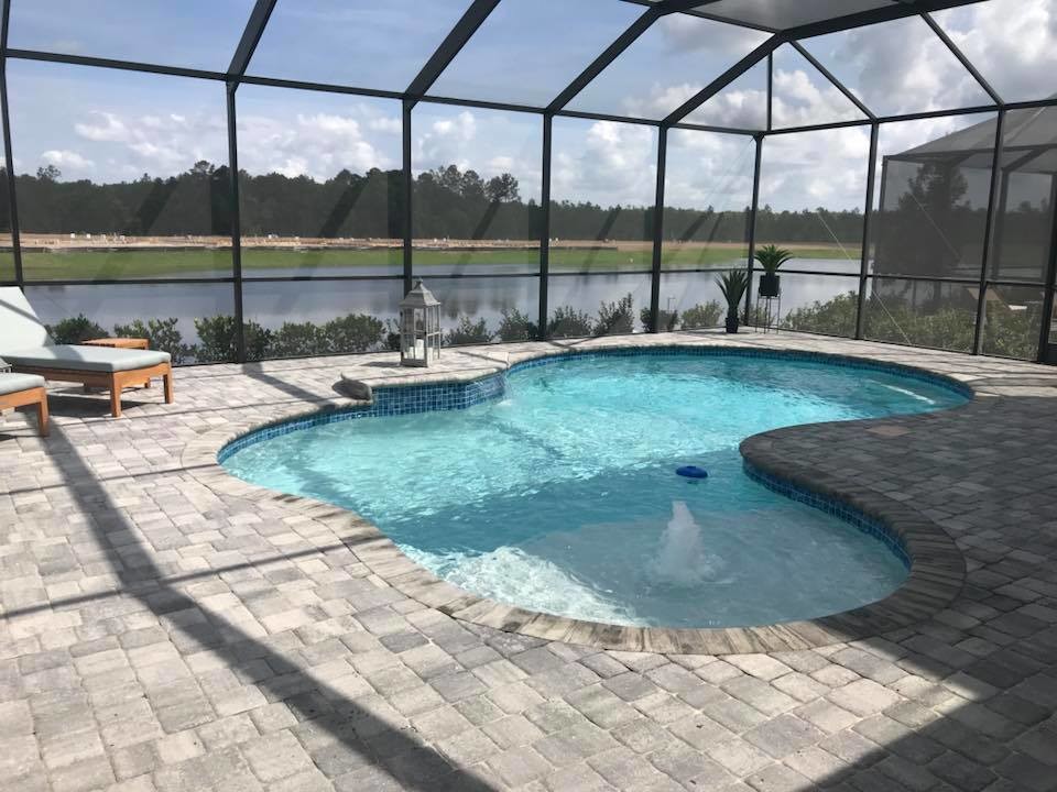 Mittelgroßer Moderner Pool hinter dem Haus in individueller Form mit Wasserspiel und Pflastersteinen in Jacksonville