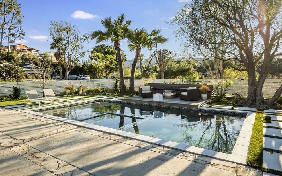 Imagen de piscinas y jacuzzis alargados retro de tamaño medio rectangulares en patio trasero con adoquines de hormigón