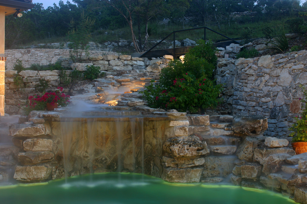 Large nautical back custom shaped hot tub in Austin with natural stone paving.