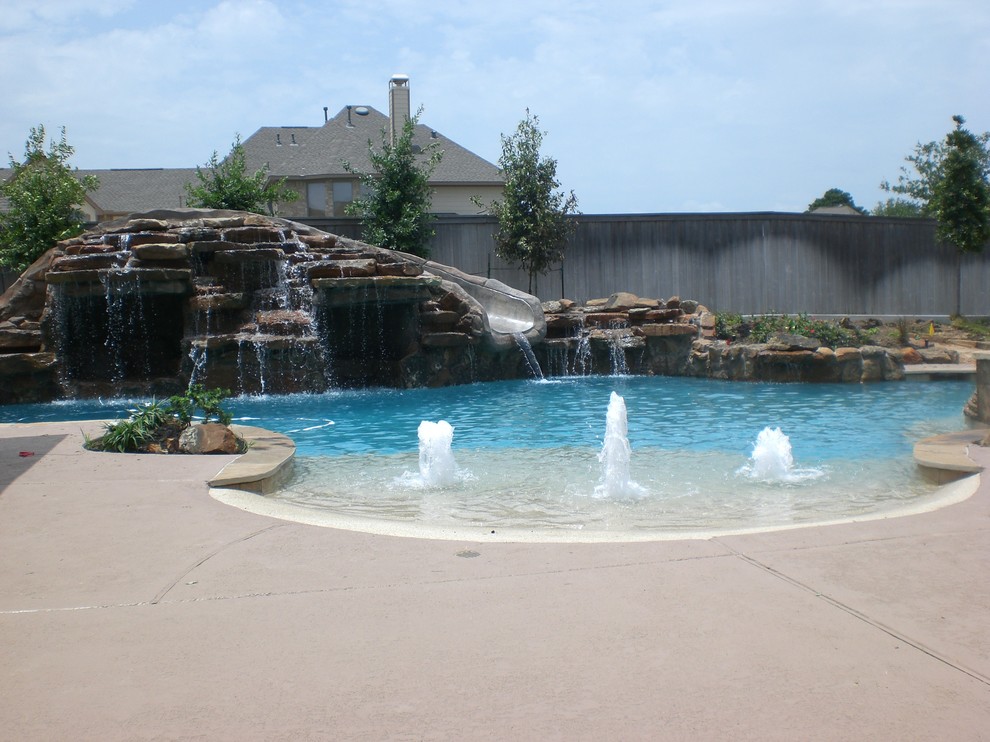 Cette photo montre une piscine naturelle et arrière chic de taille moyenne et sur mesure avec des pavés en pierre naturelle et un bain bouillonnant.
