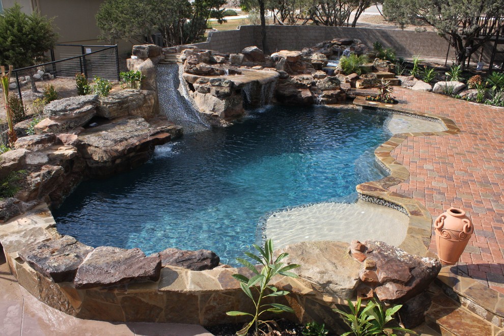 Foto di una piscina naturale stile rurale personalizzata di medie dimensioni e dietro casa con fontane e pavimentazioni in mattoni