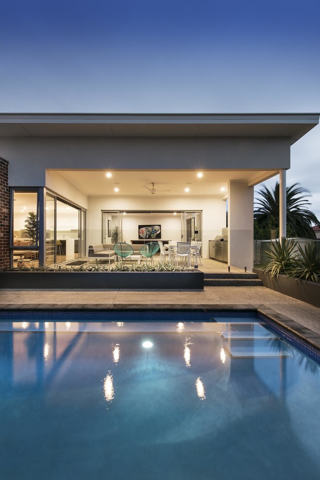 Diseño de piscina contemporánea grande rectangular en patio trasero