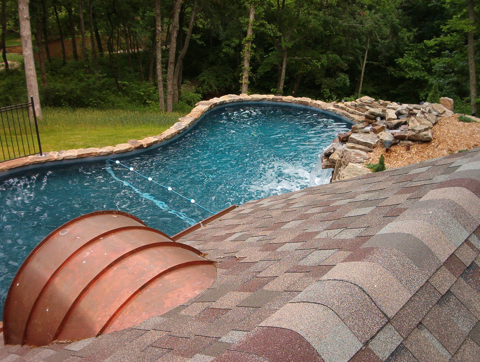 Ejemplo de casa de la piscina y piscina natural rural grande a medida en patio trasero con suelo de hormigón estampado
