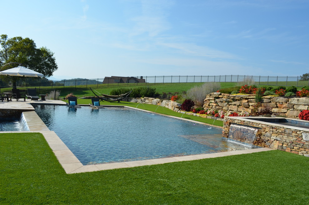 Стильный дизайн: большой спортивный, прямоугольный бассейн на заднем дворе в современном стиле с джакузи и покрытием из каменной брусчатки - последний тренд